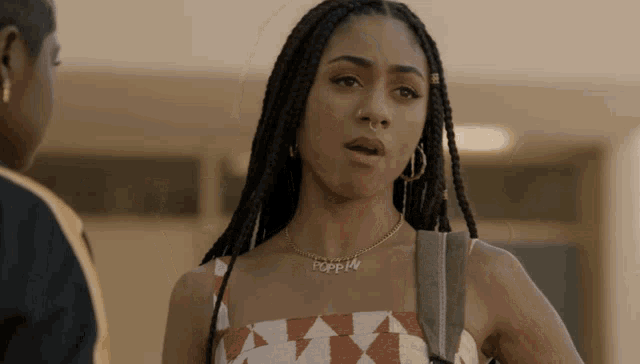 a woman wearing a necklace that says poppin