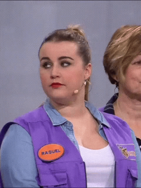a woman wearing a purple vest has a name tag that says raquel