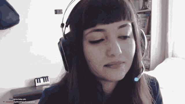 a woman wearing headphones and a microphone is looking at the camera
