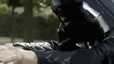 a man wearing a darth vader helmet washing his hands