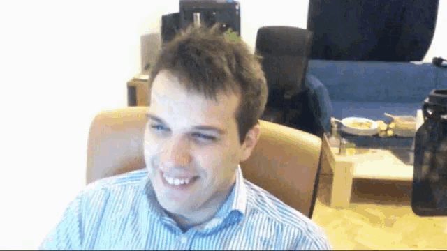 a man is smiling while sitting in a chair