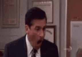 a man in a suit and tie is making a surprised face in a room .