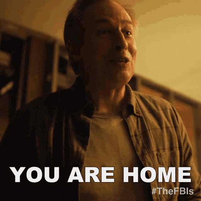 a man in a plaid shirt says " you are home " in white letters