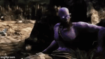 a man in a purple suit is sitting on a rock with a belt around his waist ..