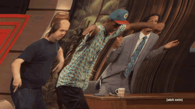 a man in a hat is playing a guitar next to a man in a blue shirt with the word adult swim on it