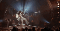 a woman is standing on a stage in front of a crowd .