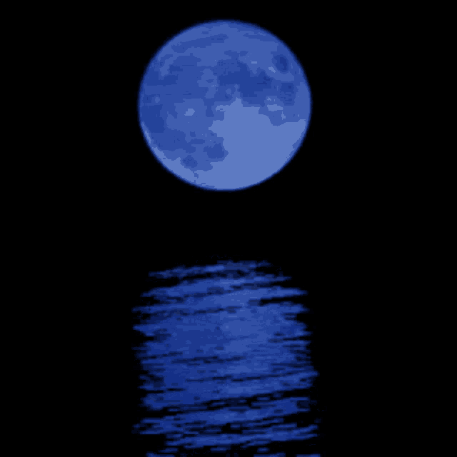 a blue full moon is reflected in a body of water