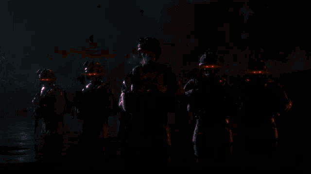 a group of soldiers standing around a fire at night