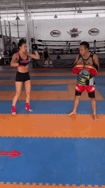a woman wearing a preda top is standing on a mat