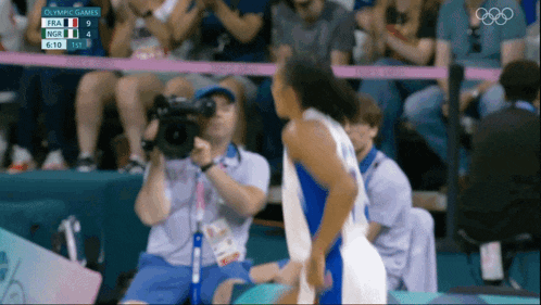 a cameraman is taking a picture of a basketball game at the olympics