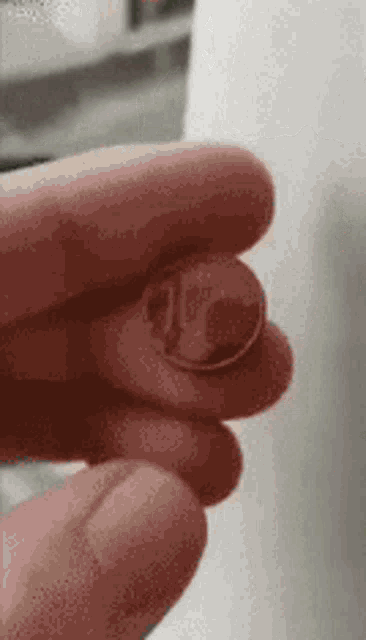 a close up of a person holding a penny in their hand .