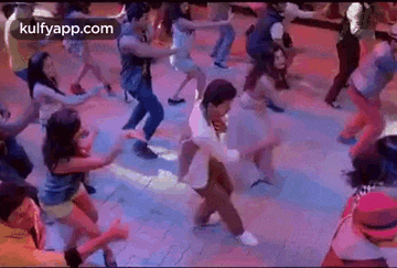 a group of people are dancing on a dance floor in a room .