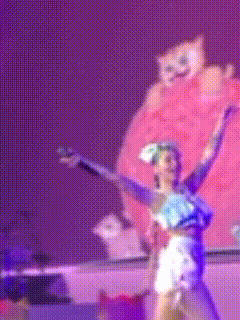 a blurry picture of a woman dancing with a cat behind her