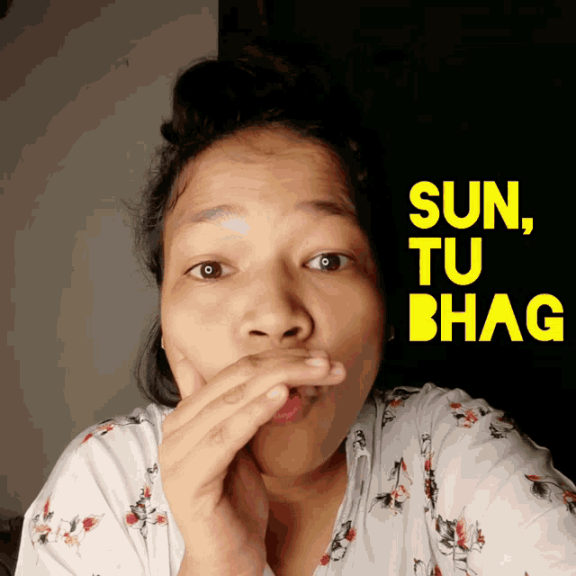 a woman covering her mouth in front of a poster that says sun tu bhaga