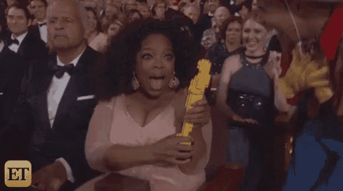 a woman in a pink dress is holding an oscar statue in her hands .