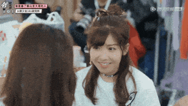 two girls are looking at each other and one has a sign on her shirt that says ' 101 '