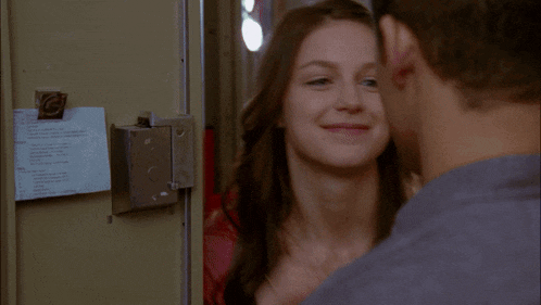 a man and a woman are looking at each other and the woman is smiling