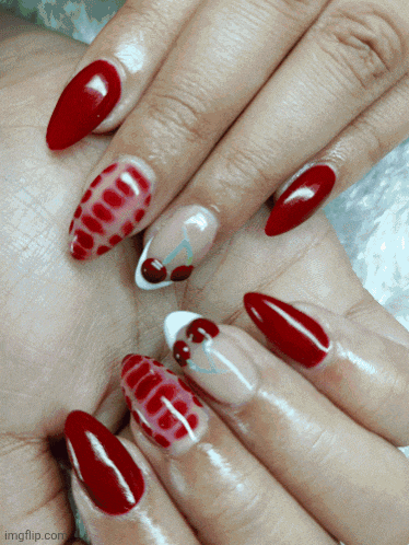 a close up of a woman 's nails with a cherry design