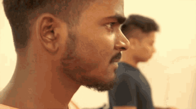 a man with a beard and mustache looks to the side