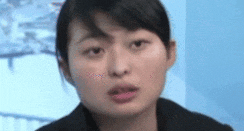 a close up of a woman 's face with a serious look on her face