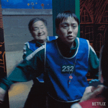 a man wearing a blue vest with 232 on it