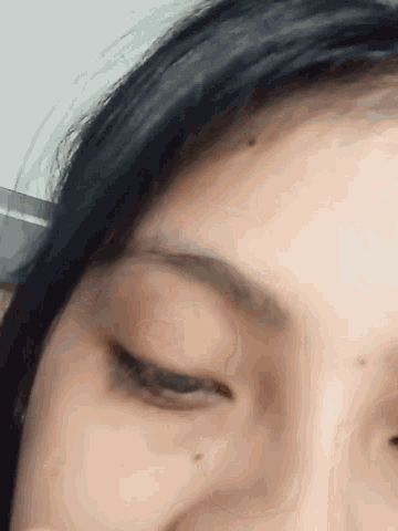 a close up of a woman 's face with a black hair
