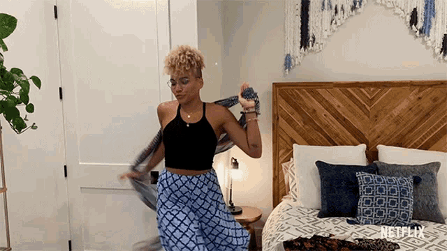 a woman is dancing in a bedroom with a netflix logo on the bottom