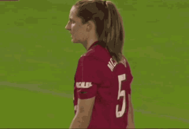 a woman is standing on a soccer field wearing a chevrolet shirt .