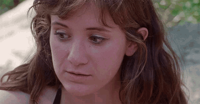a close up of a woman 's face with a serious expression