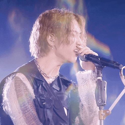 a close up of a person singing into a microphone that says ' a.t.t. technology ' on it