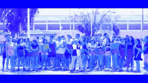 a large group of people are standing in a line and one of them is wearing a shirt with the letter o on it