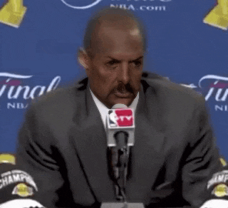 a man in a suit is talking into a microphone with the words `` job 's not finished '' written on it .