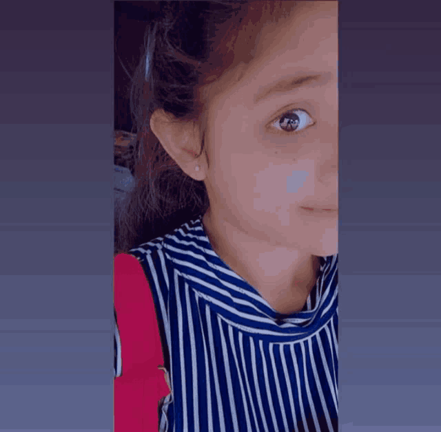 a close up of a girl 's face with a striped shirt