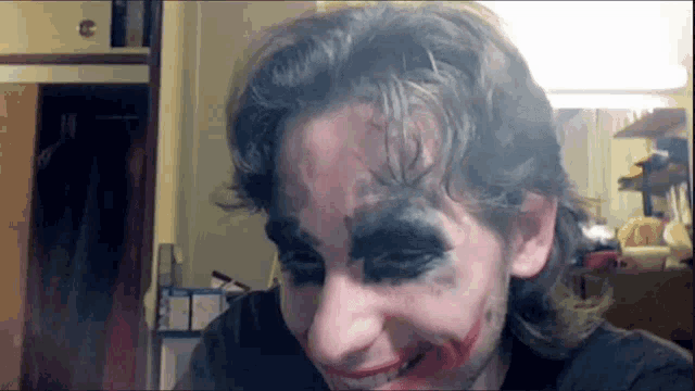 a man with makeup on his face is smiling