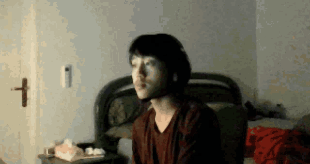 a man in a red shirt is sitting in front of a door with the number 1 on it
