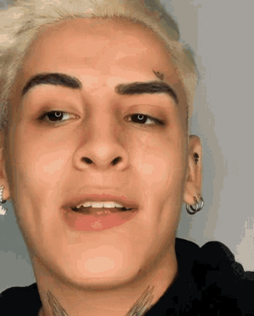 a close up of a young man 's face with a tattoo on his face .