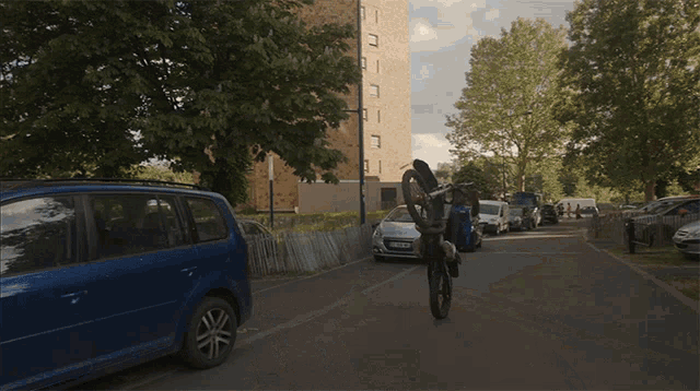 a man in a blue vest is carrying a motorcycle on his back with the letters gz on it