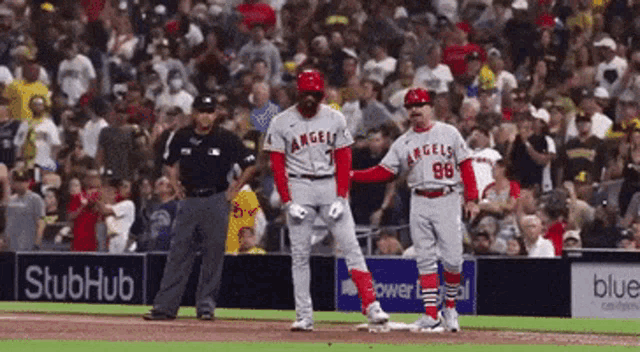 a baseball player with the number 98 on his jersey stands on the base