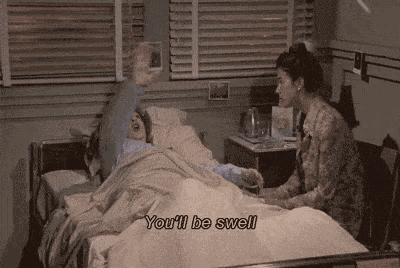 a woman is sitting next to a patient in a hospital bed and saying `` you 'll be swell '' .