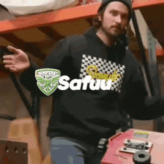 a man wearing a black hoodie with the word satuu on it .