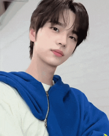 a close up of a young man wearing a blue hoodie