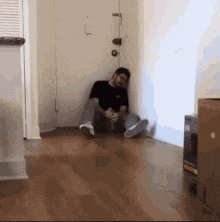a man is sitting on the floor leaning against a door .