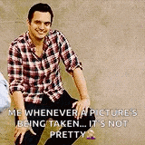 a man in a plaid shirt is sitting on the ground with his legs crossed and smiling .