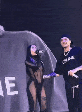 a man and a woman are standing next to each other on a stage .