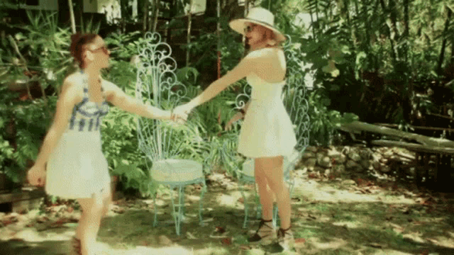 a woman in a white dress holds hands with another woman