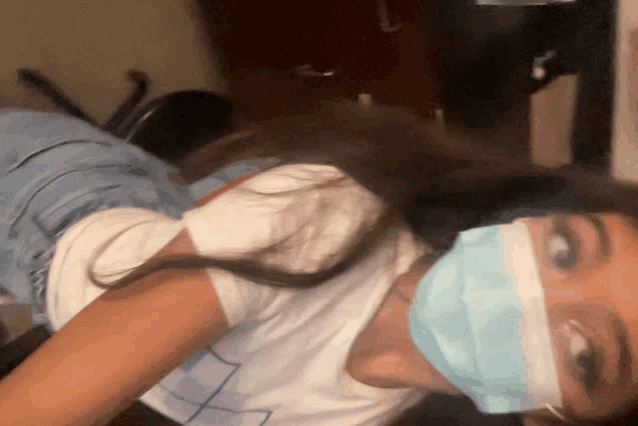 a woman wearing a face mask is laying down