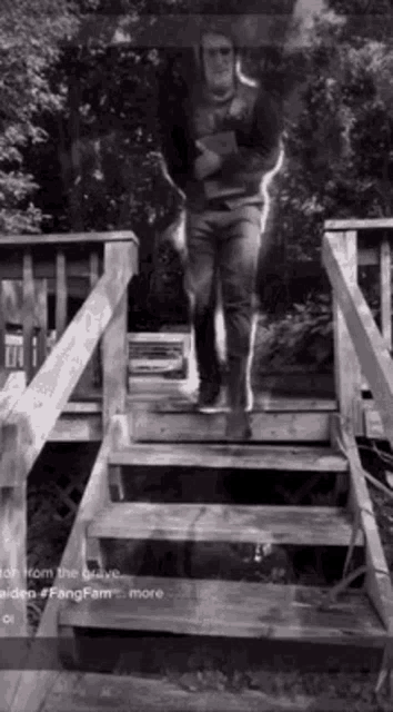 a man is standing on a set of wooden stairs .