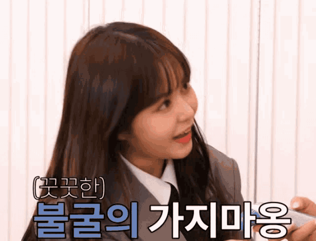 a girl in a suit and tie with korean writing on the bottom right