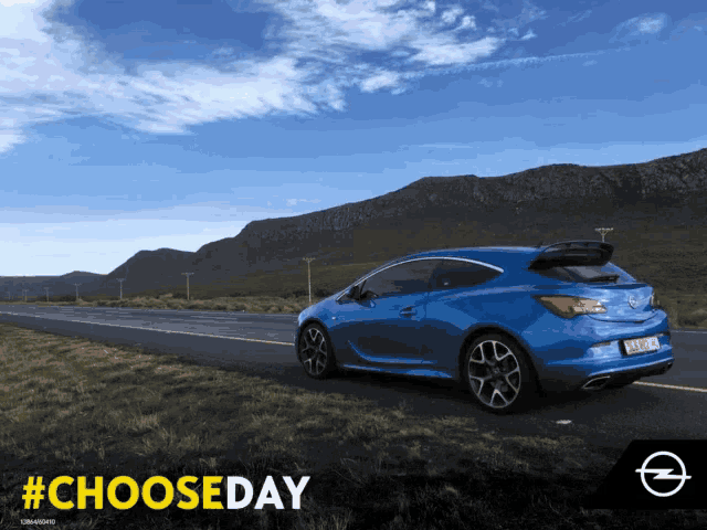a blue car is driving down a road with mountains in the background and the hashtag #chooseday