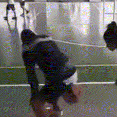 a person is doing a handstand while holding a basketball on a court .